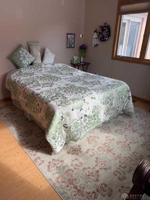 bedroom featuring baseboards and wood finished floors