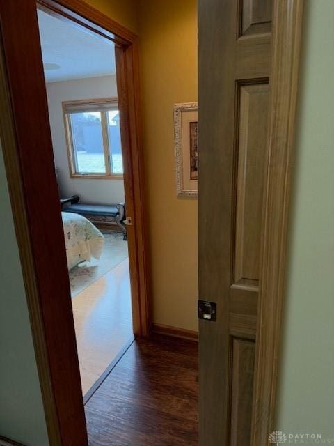 hallway featuring dark wood-style floors and baseboards