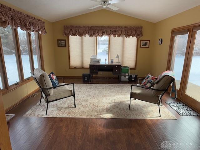 living room with ceiling fan, vaulted ceiling, baseboards, and wood finished floors