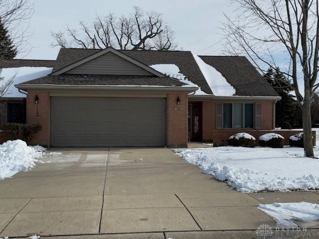 ranch-style house with a garage, concrete driveway, and brick siding