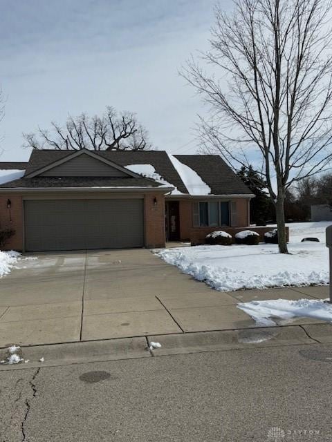 view of front facade with a garage, driveway, and brick siding