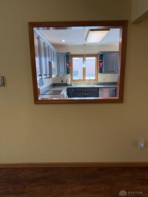 kitchen featuring white microwave, range, dishwasher, open shelves, and dark wood finished floors