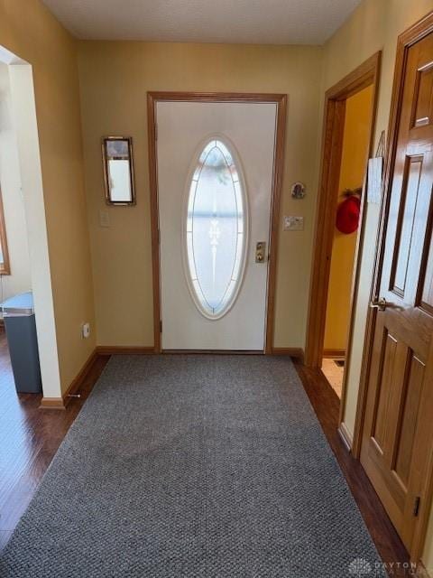 entryway with dark wood finished floors and baseboards