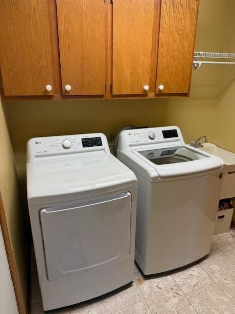 clothes washing area featuring cabinet space and washer and dryer