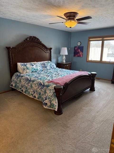 bedroom featuring carpet floors, a textured ceiling, baseboards, and a ceiling fan