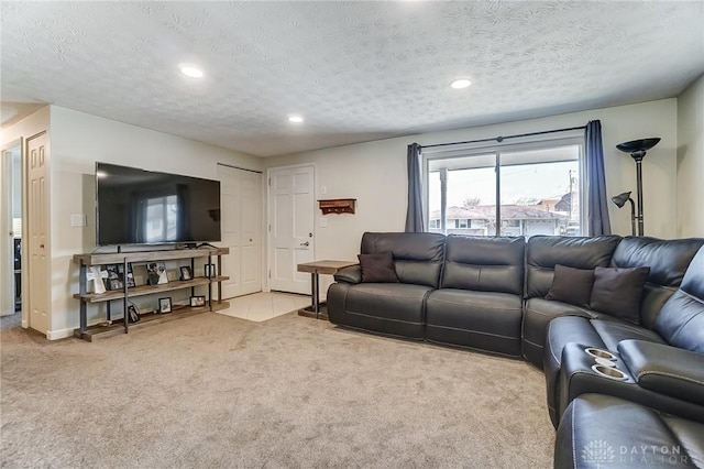 living area featuring a textured ceiling, recessed lighting, and light colored carpet