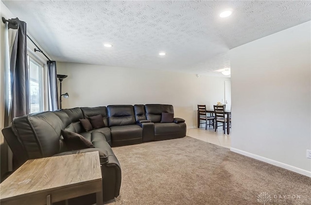 living room with a textured ceiling, recessed lighting, baseboards, and light colored carpet