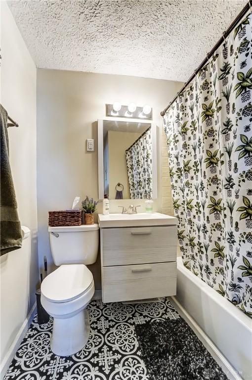 bathroom with shower / tub combo, toilet, tile patterned flooring, a textured ceiling, and vanity