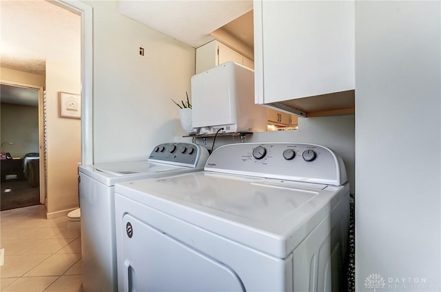 laundry room with washer and clothes dryer and light tile patterned floors