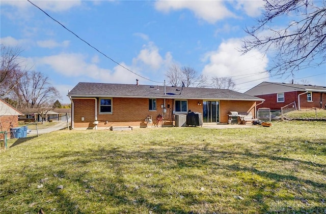 back of house featuring a patio area, a yard, fence, and brick siding