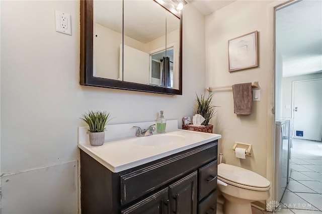 bathroom with toilet, vanity, and tile patterned floors