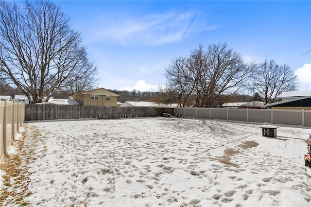 yard layered in snow with a fenced backyard