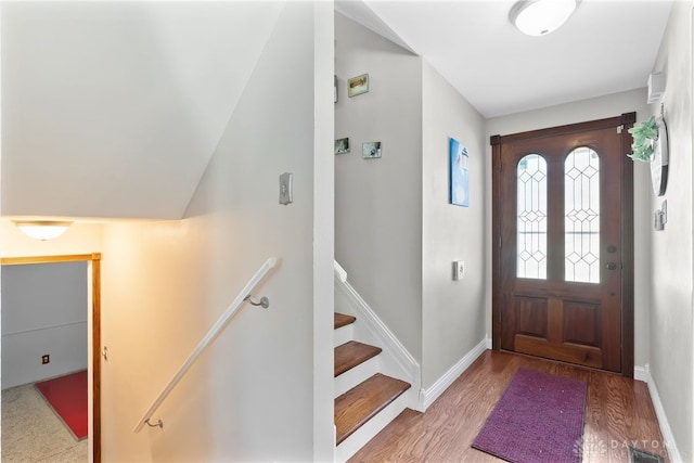 foyer entrance featuring light wood-style floors, baseboards, stairway, and visible vents