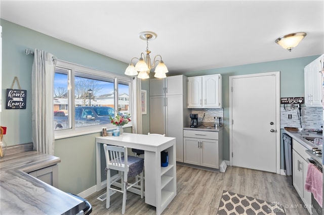 kitchen with white cabinets, pendant lighting, light countertops, open shelves, and backsplash