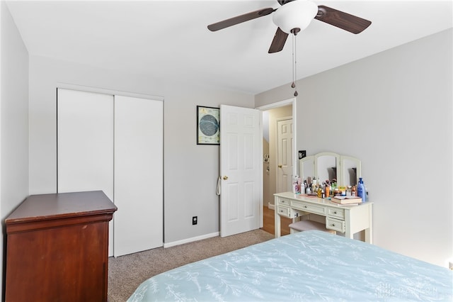 bedroom featuring a ceiling fan, a closet, and light colored carpet