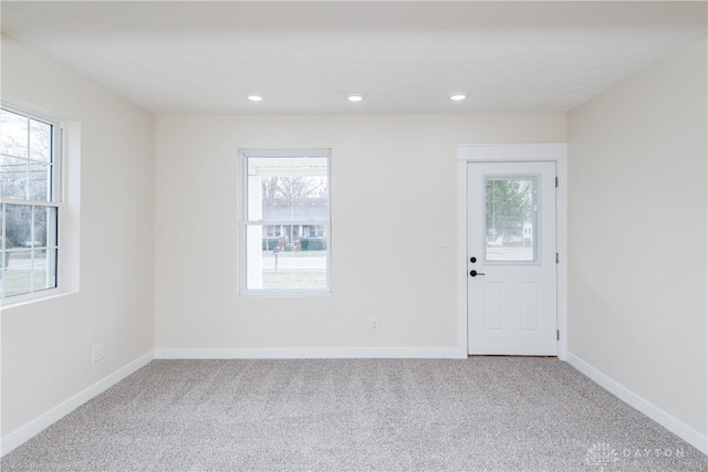 empty room featuring carpet, baseboards, and recessed lighting