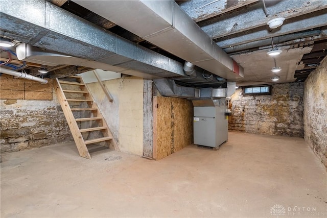 basement with heating unit and stairway