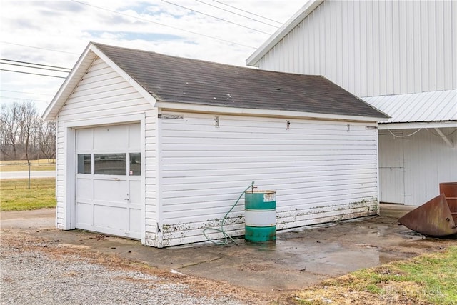 view of side of property featuring a garage and roof with shingles