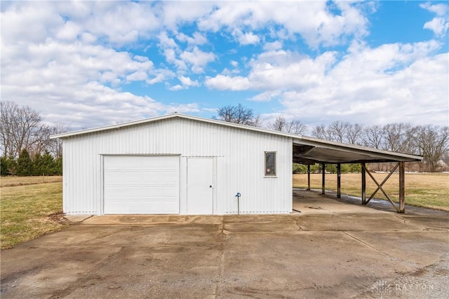 garage featuring concrete driveway and a detached garage