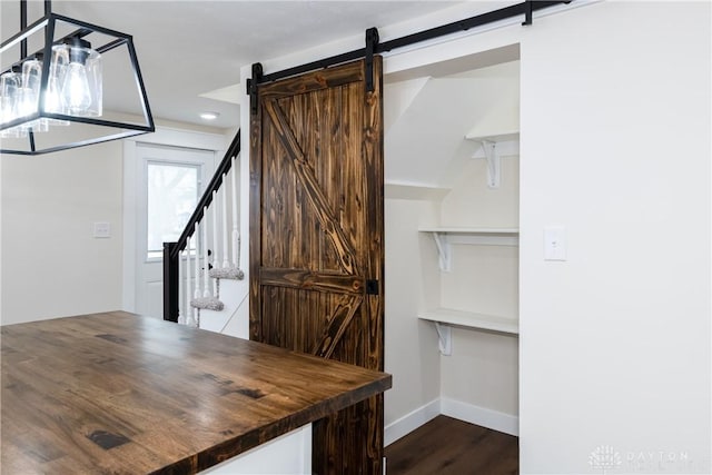 interior space with a barn door and dark wood-type flooring