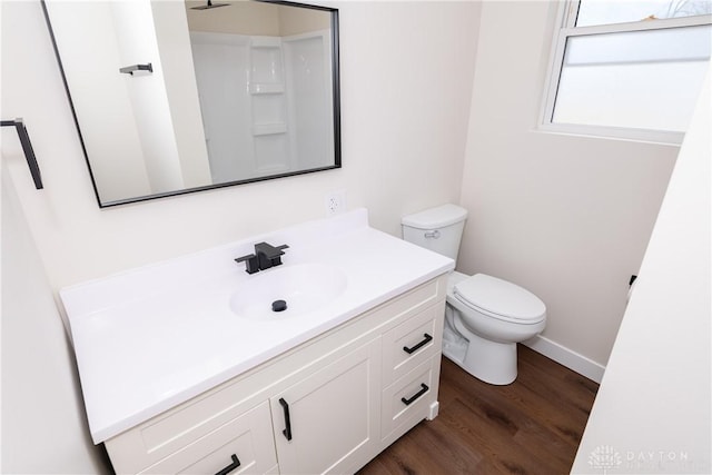 bathroom featuring baseboards, vanity, toilet, and wood finished floors