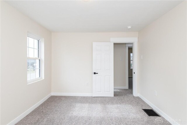 unfurnished room featuring light carpet, baseboards, and visible vents