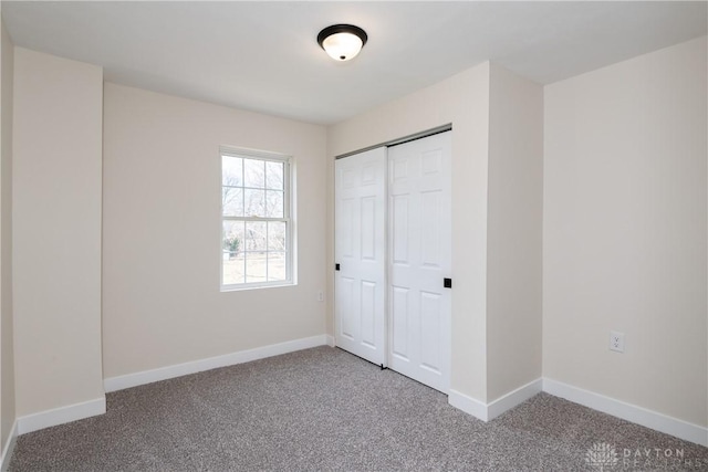 unfurnished bedroom featuring a closet, carpet, and baseboards