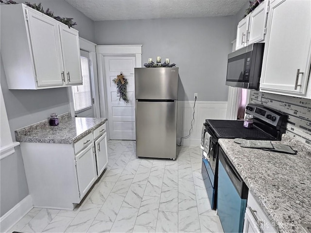 kitchen featuring electric range oven, marble finish floor, freestanding refrigerator, and dishwasher