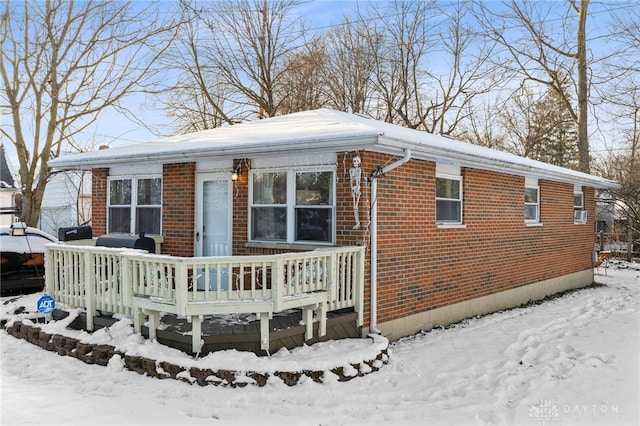 exterior space with brick siding and a wooden deck