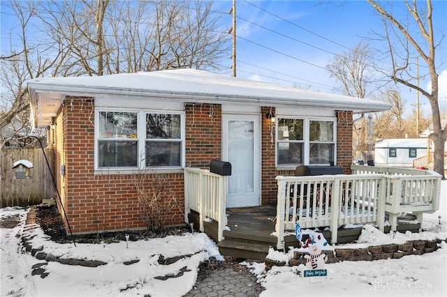 bungalow-style house with brick siding and a deck