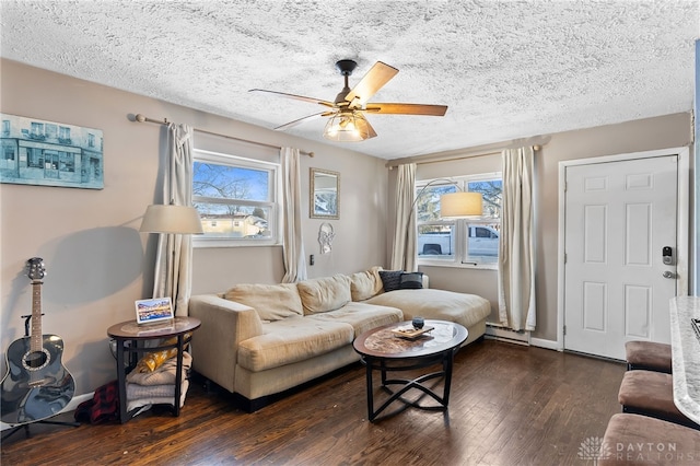 living room featuring ceiling fan, a baseboard radiator, dark wood finished floors, and a healthy amount of sunlight