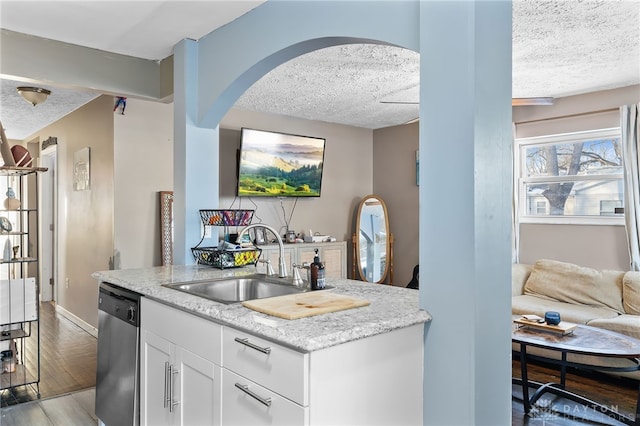 kitchen featuring a sink, light stone counters, white cabinets, and dishwasher