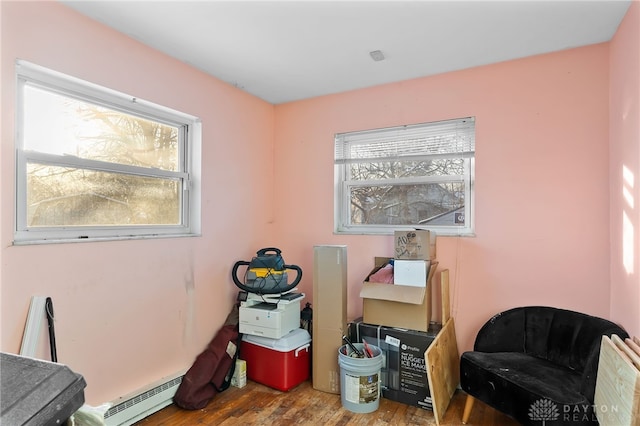 interior space featuring a baseboard heating unit and wood finished floors