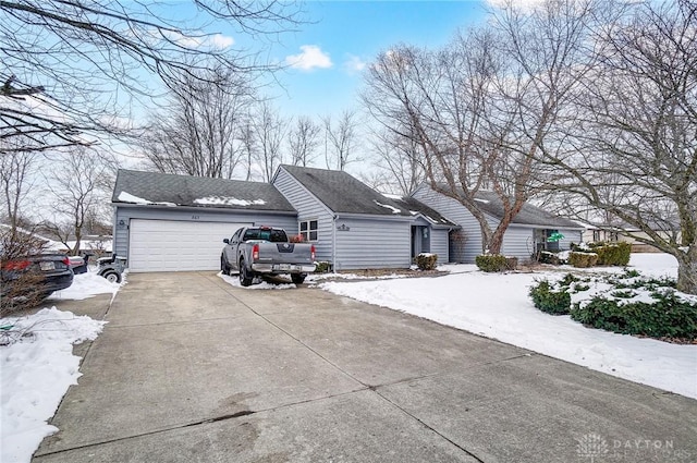 view of front facade featuring concrete driveway, a shingled roof, and an attached garage