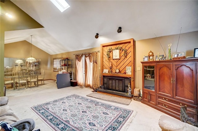 living area featuring lofted ceiling, light carpet, and a glass covered fireplace