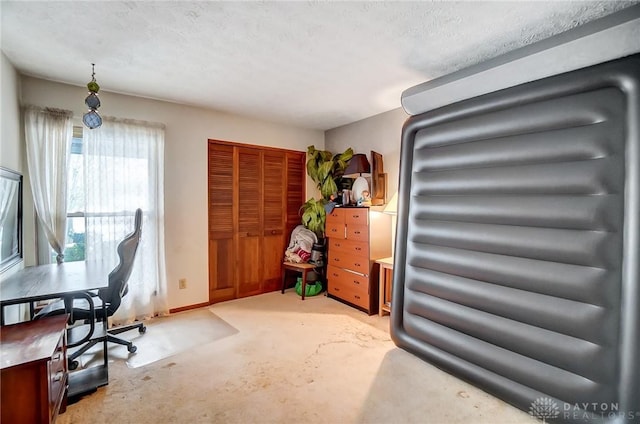 carpeted office featuring a textured ceiling and baseboards