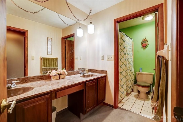 bathroom featuring double vanity, tile patterned flooring, a sink, and toilet