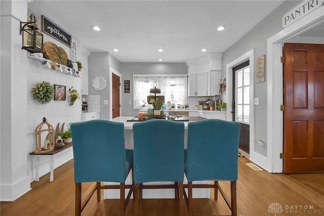 dining room with recessed lighting, visible vents, plenty of natural light, and wood finished floors