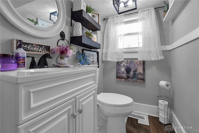 bathroom featuring visible vents, a textured ceiling, vanity, and wood finished floors