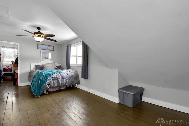 bedroom featuring lofted ceiling, dark wood-type flooring, and baseboards