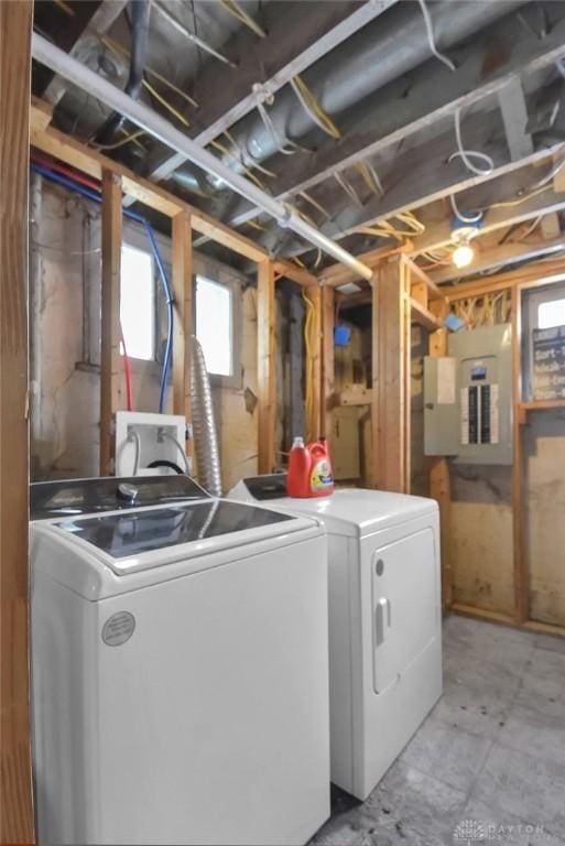 clothes washing area with laundry area, electric panel, and washer and clothes dryer