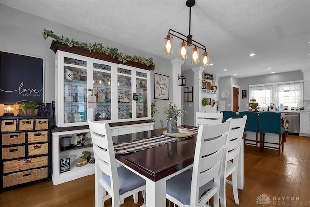 dining room featuring a textured ceiling, dark wood finished floors, and recessed lighting