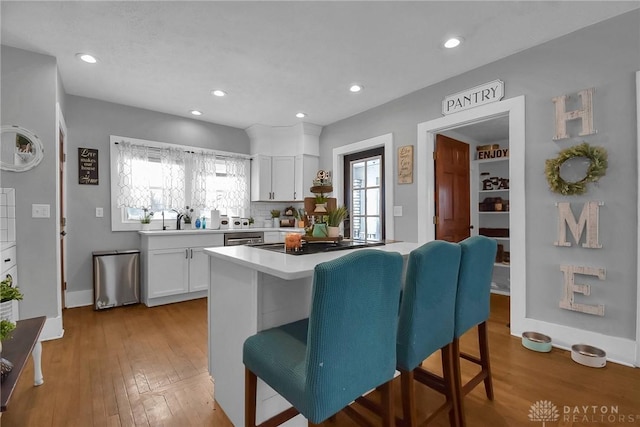 kitchen featuring light wood-type flooring, light countertops, and white cabinetry