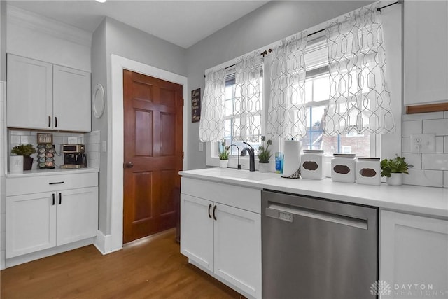 bar featuring dishwasher, wood finished floors, a sink, and a healthy amount of sunlight