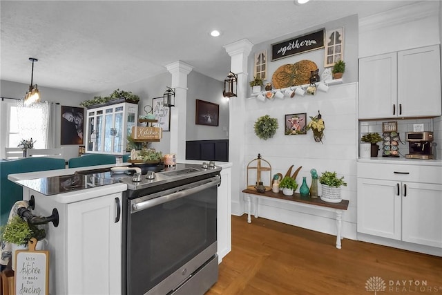 kitchen featuring stainless steel electric range oven, backsplash, glass insert cabinets, and white cabinets