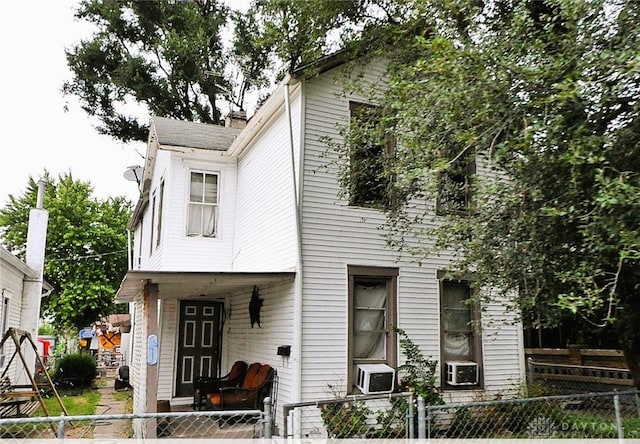 view of front of property with a fenced front yard and cooling unit