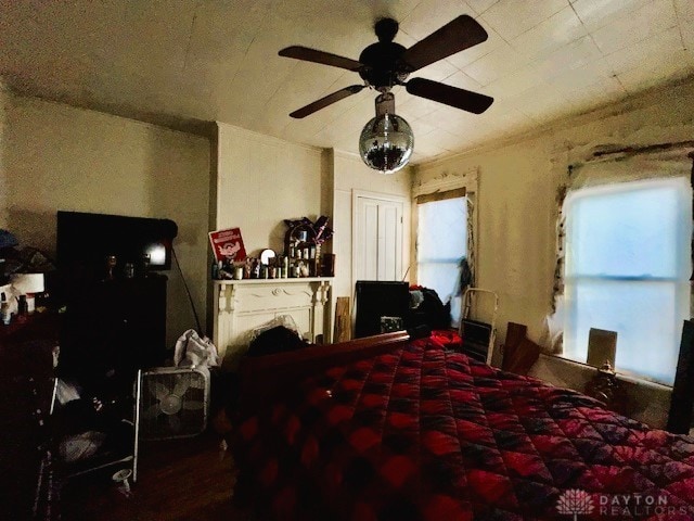 bedroom featuring ceiling fan and a fireplace