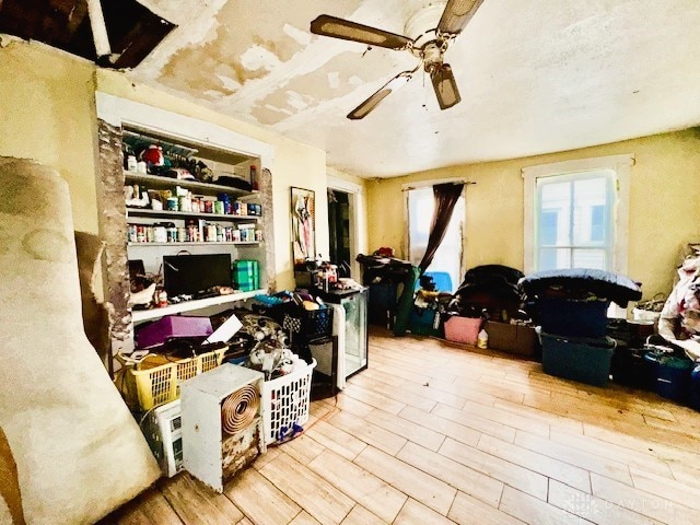 home office with light wood-style floors and a ceiling fan