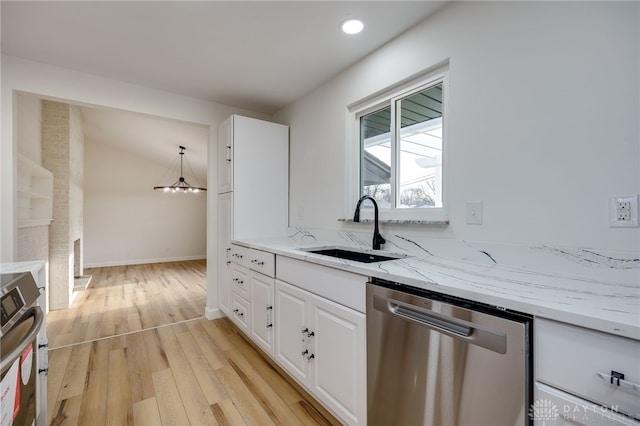 kitchen with light stone counters, a sink, white cabinets, stainless steel dishwasher, and pendant lighting