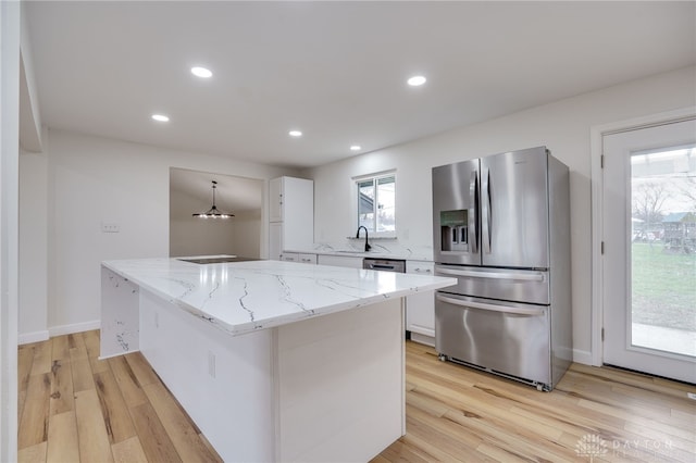 kitchen with a center island, hanging light fixtures, white cabinetry, a sink, and stainless steel fridge with ice dispenser